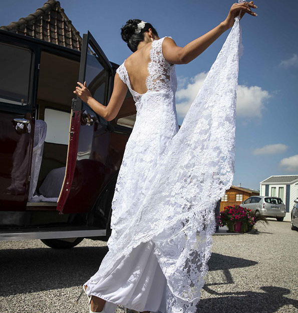 la mariée sort de son auto et prend sa robe en main