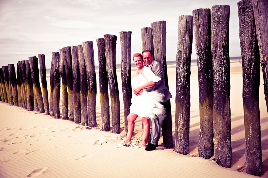 COUPLE COULEUR DEVANT UNE RANGEE DE PIEUX DE BLERIOT PLAGE