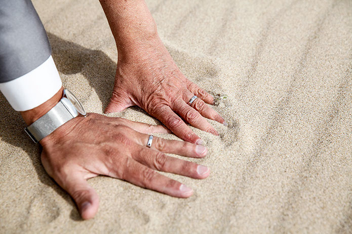 MAINS COTE A COTE APPUYEE DE LA SABLE POUR PRESENTER LES ALLIANCES