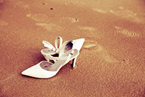 PAIRE DE CHAUSSURES POSEE SUR LA PLAGE LORS DE LA PRISE DE VUE